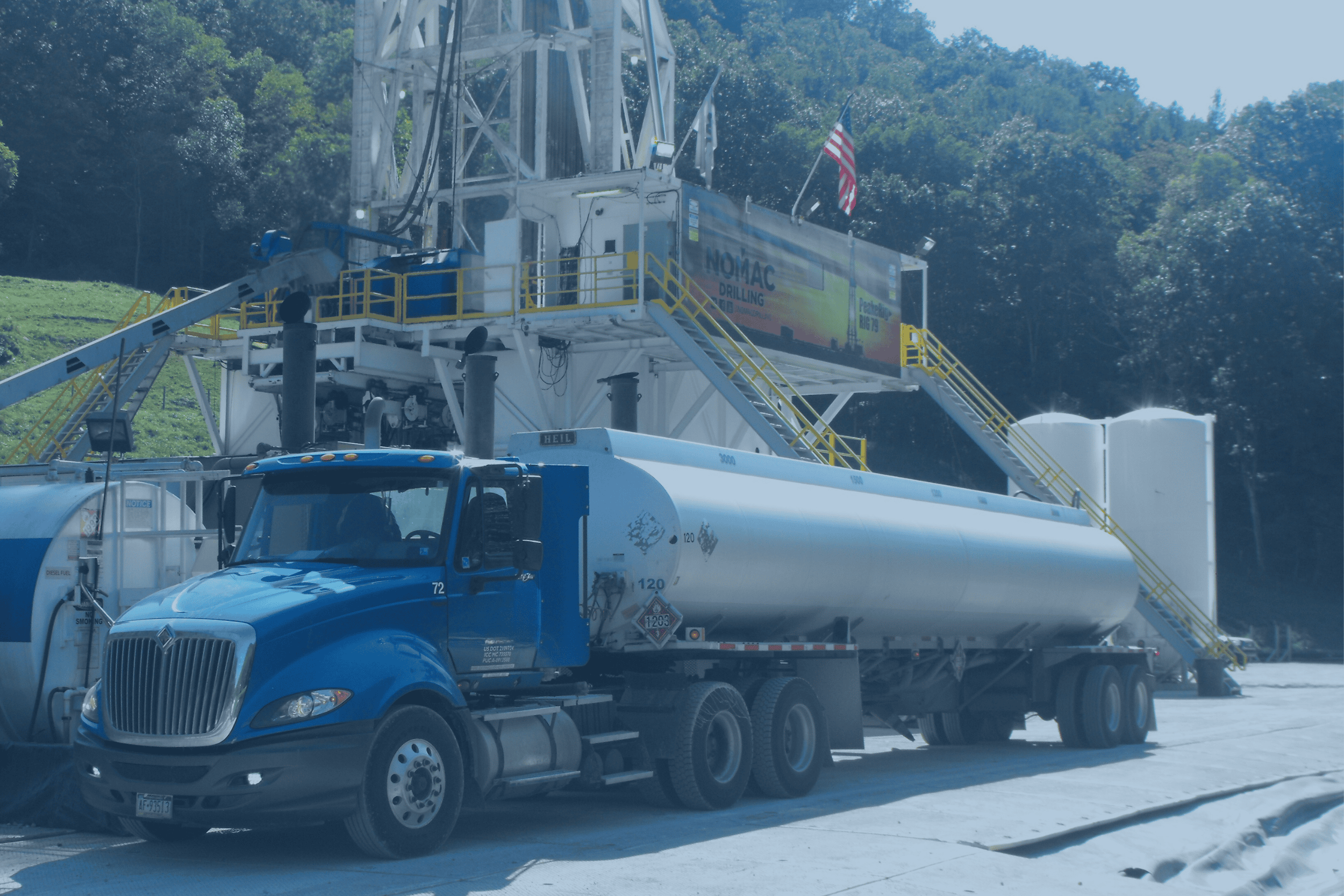 "Blue tanker truck at fuel terminal loading station"