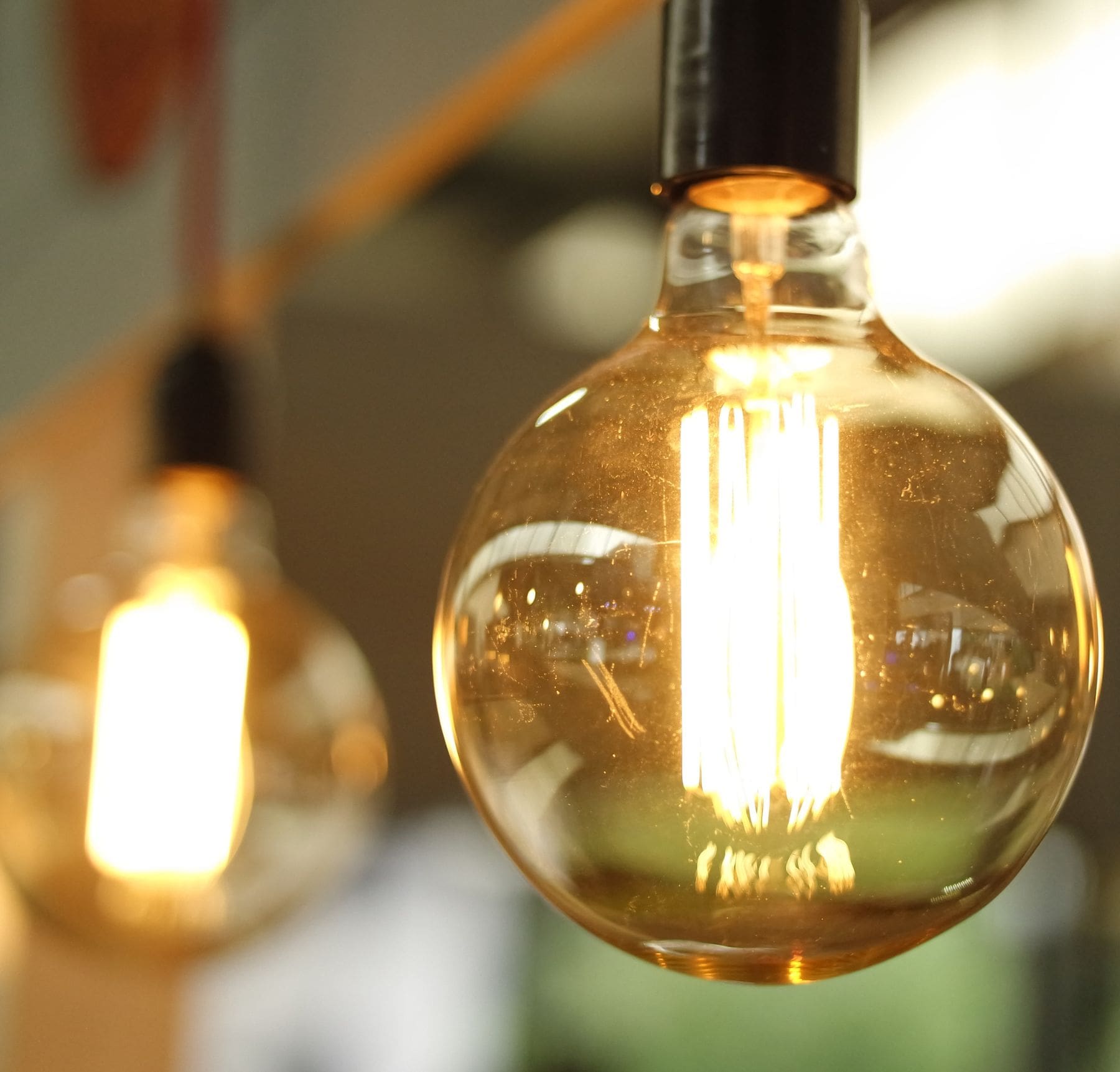 Close-up of a glowing vintage-style Edison light bulb, symbolizing energy and innovation.